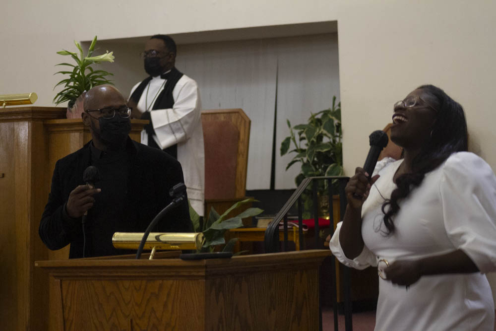 Brittany Bogan and Deacon Johnny Edwards singing during an in-person Sunday service.