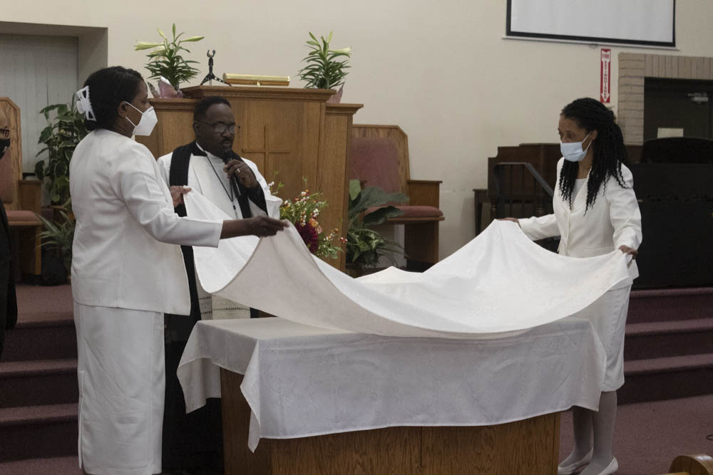Gloria Starling and Iona Edwards folding a sheeting during Holy Communion. 
