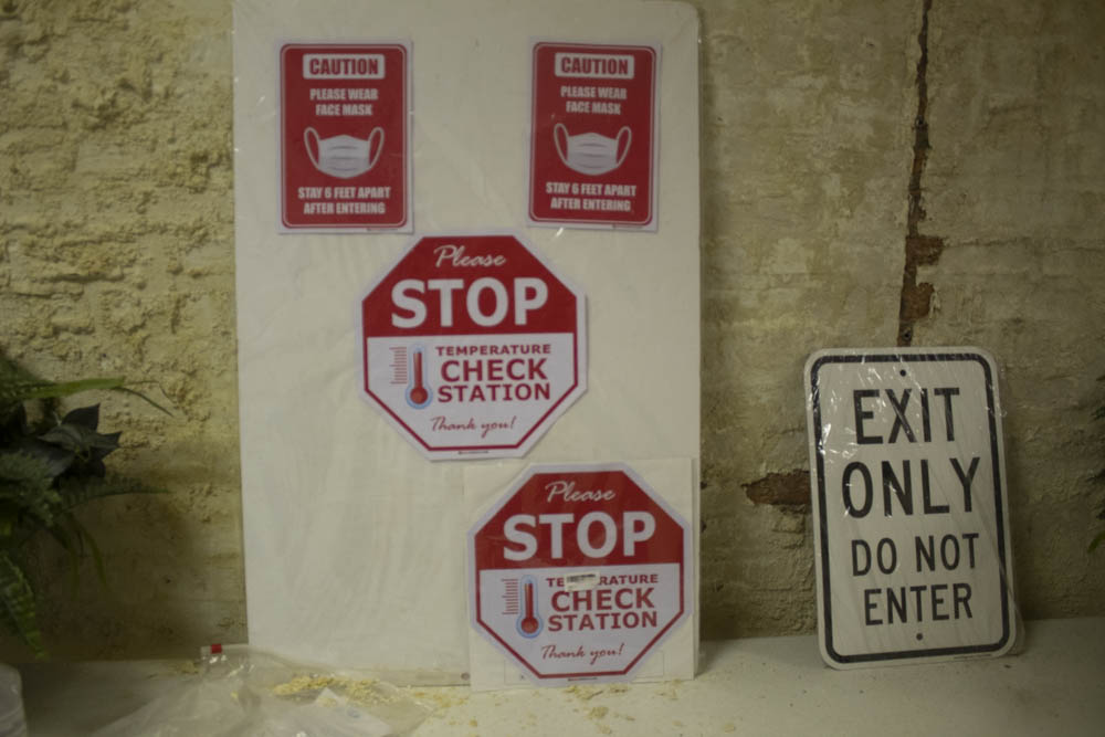 Temperature check station signs at the church's entrance.